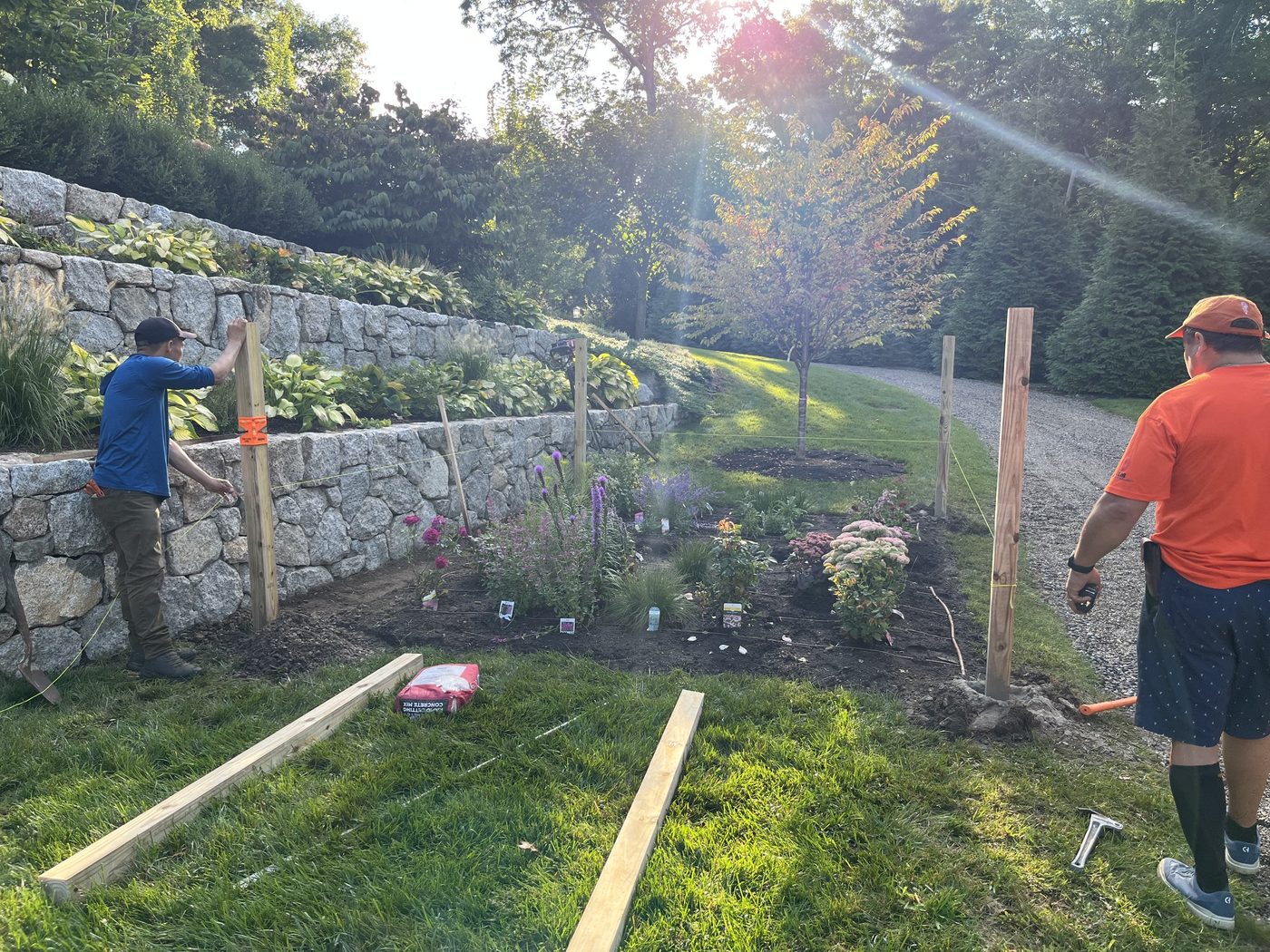 Setting posts along the new stone retaining wall